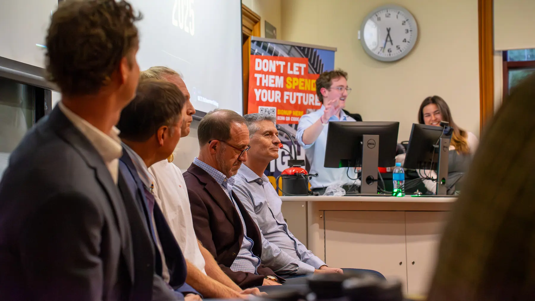 Panel-style event room with seated attendees and speaker at the front