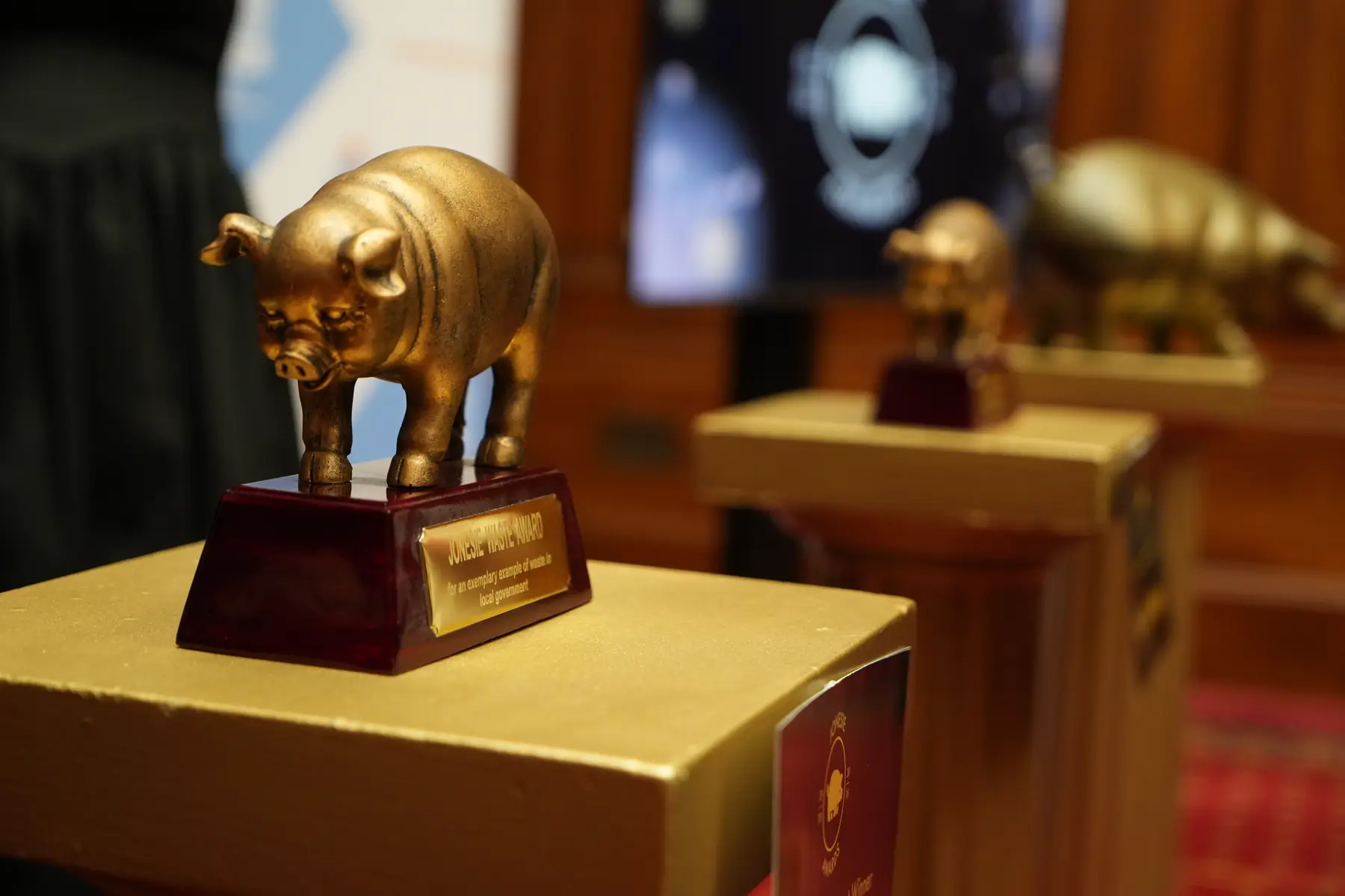 Gold pig-shaped award on a pedestal with shallow depth of field